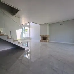 Ambiente amplo com piso de mármore polido e lareira no centro da sala.
