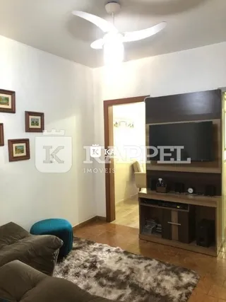 Sala de estar com sofá e painel de televisão.