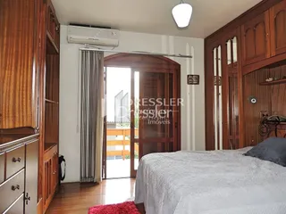 Quarto com paredes de madeira e cama em um imóvel.