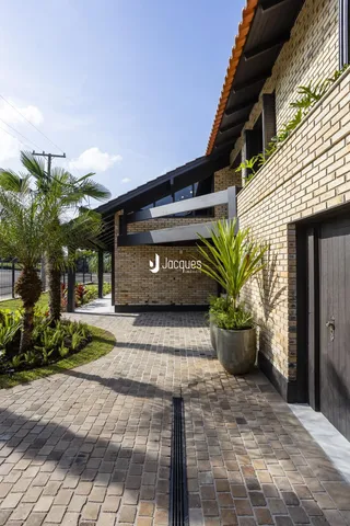 A fachada de uma residência em Lajeado com jardim e pátio pavimentado.