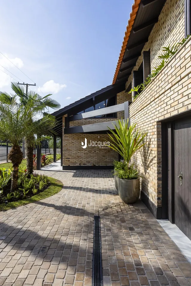 A fachada de uma residência em Lajeado com jardim e pátio pavimentado.