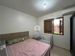 Quarto com cama e janela de madeira no imóvel.