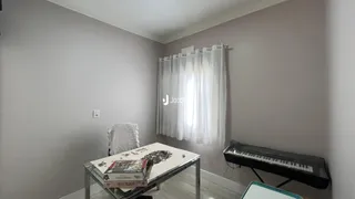 Ambiente interno com paredes cinzas e cortinas brancas em uma sala.