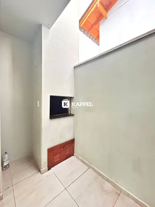 Hall de entrada com paredes brancas e painéis de madeira.