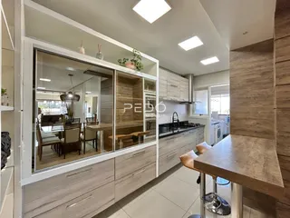 Vista da cozinha com armários e divisória de vidro.