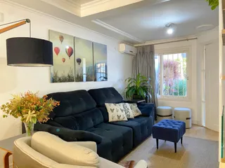 Sala de estar com sofá azul escuro e decoração moderna em um apartamento.