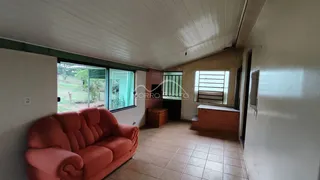 Sala de estar com sofá laranja e vista para o exterior.