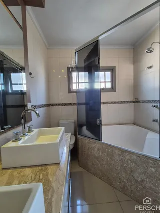 Foto de um banheiro com bancada e banheira.