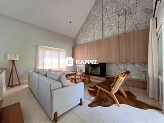 Sala de estar com sofá branco e lareira.