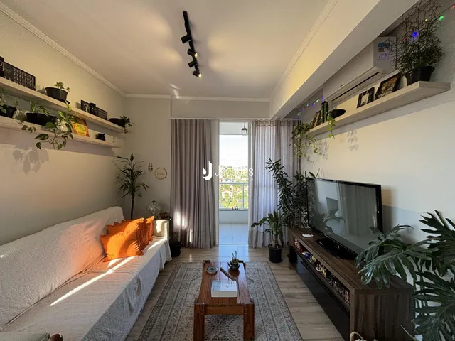 Esta é uma sala de estar com sofá e decoração de plantas.