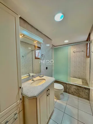 Foto de um banheiro interno com piso de cerâmica e box de vidro.
