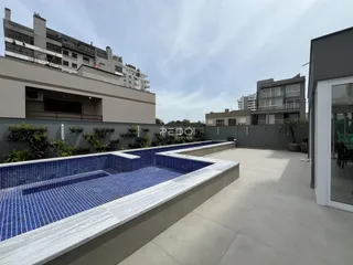Vista de uma área externa com canaletas decorativas e piso de concreto em um imóvel em Lajeado.