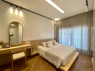Quarto moderno com piso de madeira e cortinas claras.