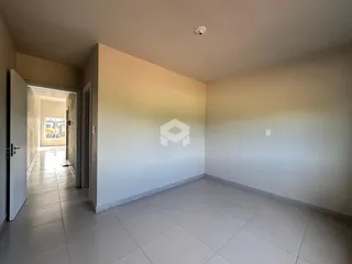 Um corredor com piso de cerâmica claro é visível na propriedade.