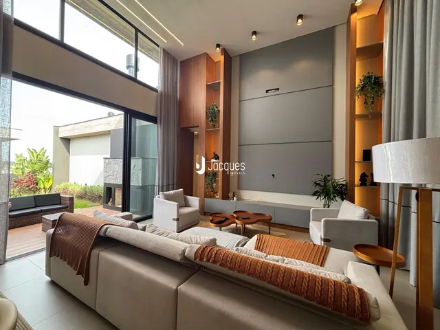 Sala de estar moderna com grandes janelas que dão vista para o exterior.