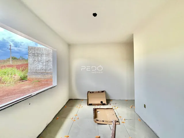 Interior de uma sala em construção com vista para o exterior.