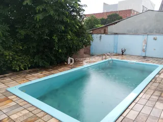 Foto de uma piscina externa com piso de tijolos ao redor.