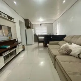 Foto interna de uma sala com sofá e armários em um imóvel.