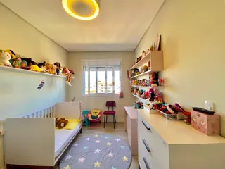 Quarto com cama de madeira e prateleiras decoradas em uma residência.