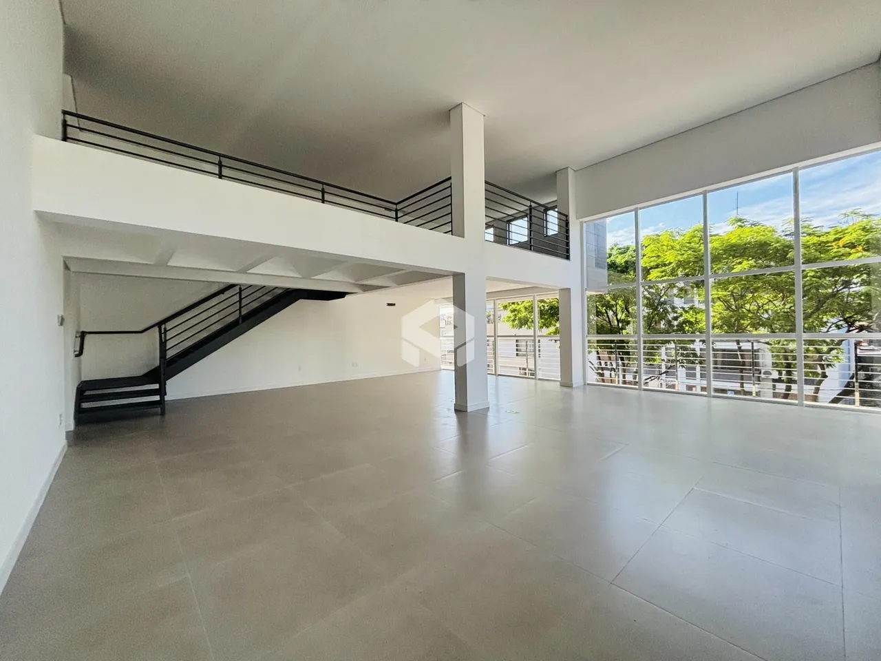Espaço amplo com pé direito alto e vista para o exterior.