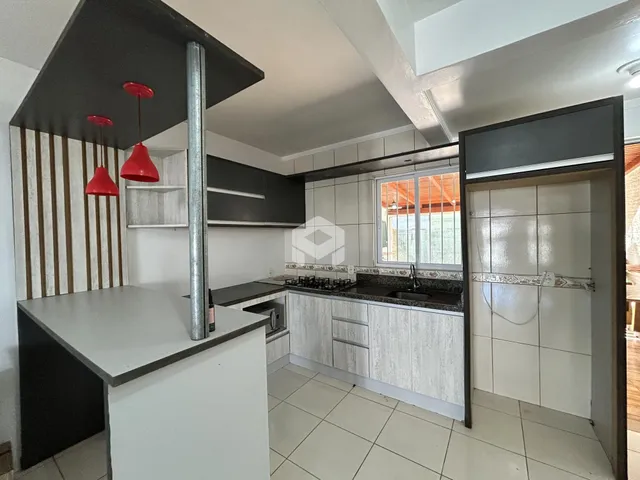 Vista interna de uma cozinha moderna com armários e revestimentos claros.