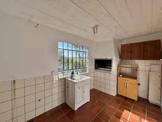 Foto de um cômodo interno com piso de tijolo e paredes brancas.