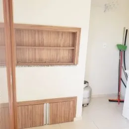 Parede interna com painel de madeira clara em um imóvel.