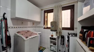 Foto de um interior com armários brancos e paredes de azulejo.