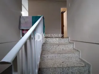 Vista de uma escadaria interna com corrimão branco.
