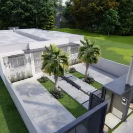 Foto de uma área externa com piso de concreto e vegetação.