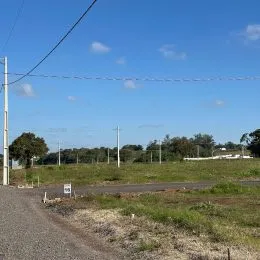 Vista externa de uma estrada de terra com vegetação e céu azul em Lajeado, Brasil.