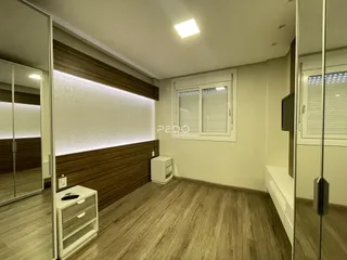 Sala de estar com piso de madeira e painel de madeira na parede.