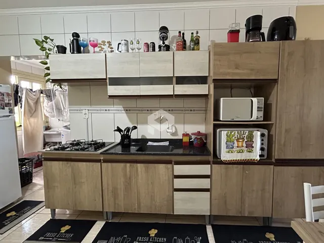 Cozinha com armários de madeira e revestimento cerâmico.