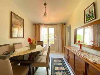 Ambiente interno de uma sala de jantar com decoração e janelas.