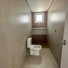 Foto de um banheiro com vaso sanitário e paredes claras.