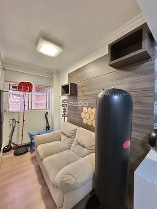 Sala de estar com sofá e parede de madeira em um imóvel no Brasil.