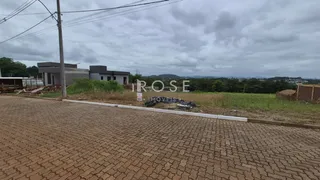 Vista externa de uma propriedade com terreno e construção ao fundo.