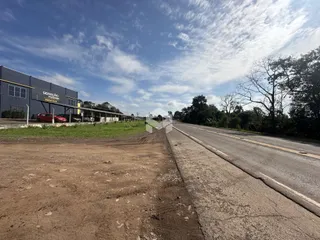 Vista externa de uma propriedade em Lajeado, Brasil, mostrando uma estrada e um prédio industrial.