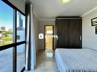 Quarto com cama e armário de madeira em um apartamento em Lajeado.