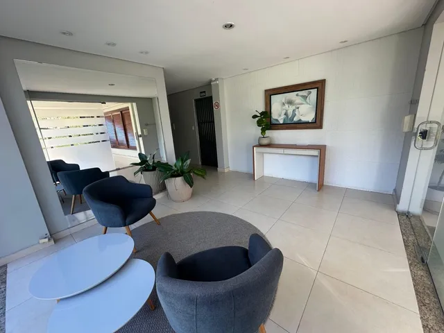 Sala de estar com piso de cerâmica e assentos modernos em um imóvel em Lajeado.
