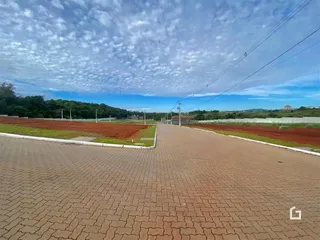 Vista da propriedade mostrando uma estrada pavimentada e áreas de terra ao redor.