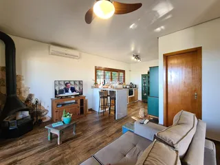 Sala de estar com lareira e piso de madeira.