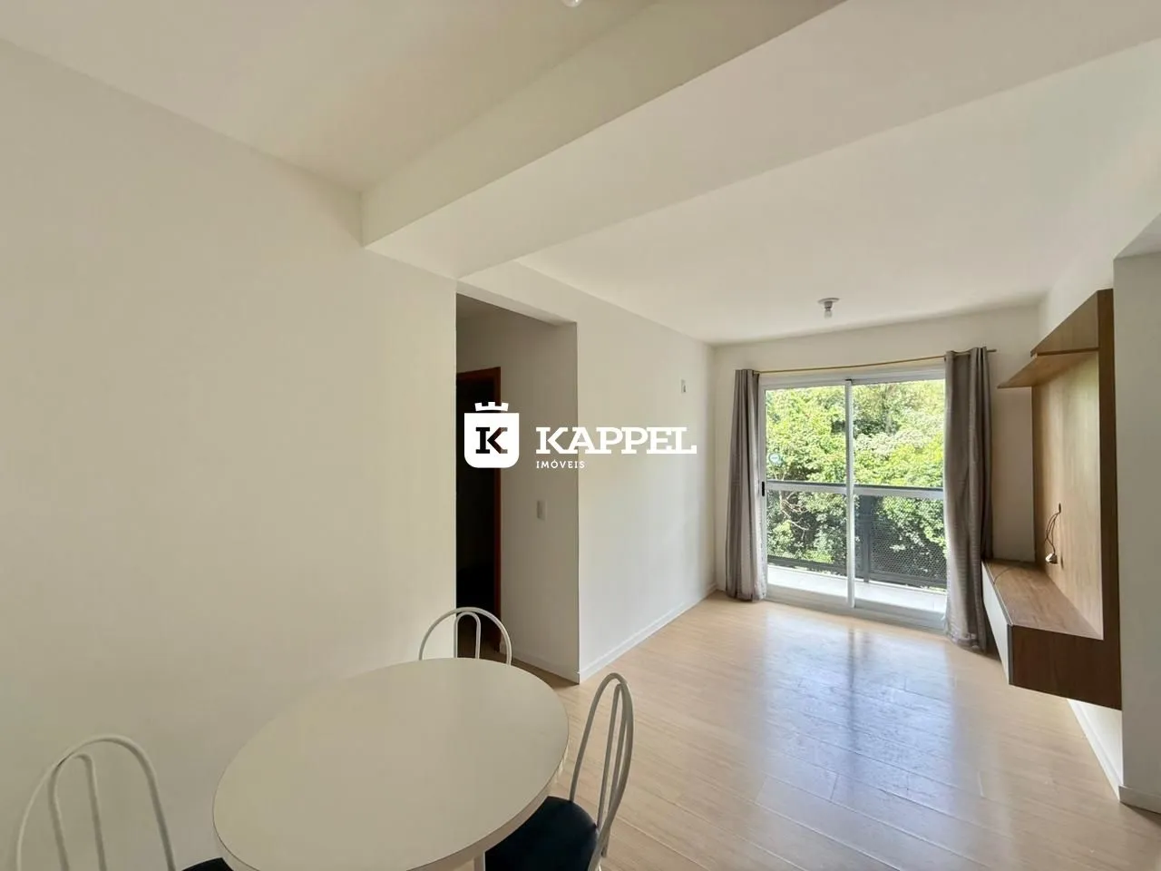 Foto de um ambiente interno com mesa de jantar e piso de madeira clara.