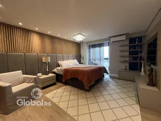 Quarto moderno com cabeceira estofada e painel de madeira na parede.