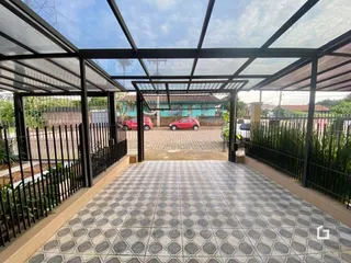 Piso cerâmico de área externa coberta com estrutura de pérgola.