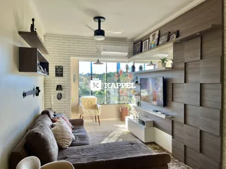 Sala de estar com sofá e painel de madeira na área de Lajeado.
