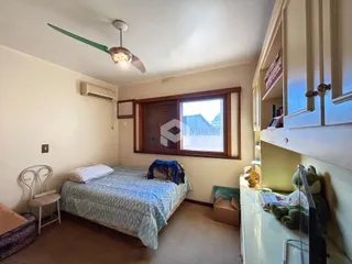Quarto com janela de madeira e ar-condicionado instalado.