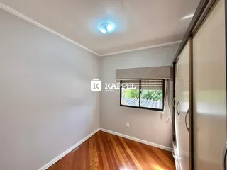 Foto de um cômodo interno com paredes brancas e piso de madeira.