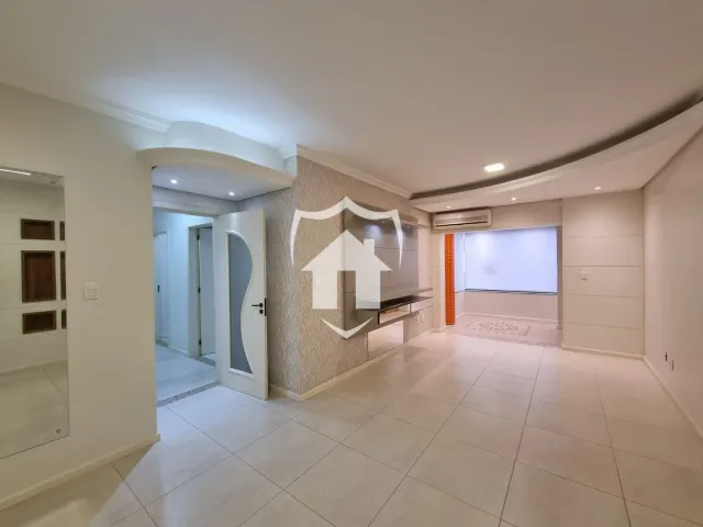 Ambiente interno de uma sala com piso de cerâmica clara e paredes brancas.
