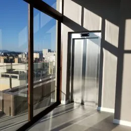Vista de um interior com porta de vidro que dá acesso a uma área externa.
